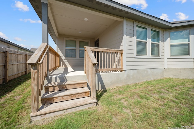 property entrance with a lawn