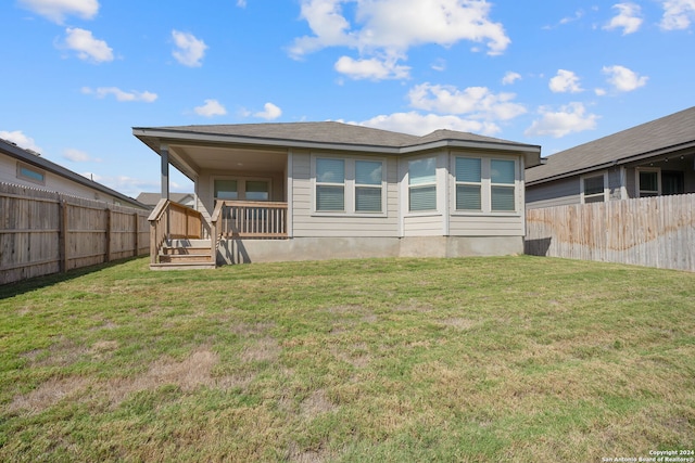 rear view of property with a yard