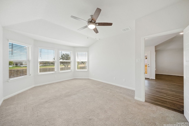 spare room with light carpet, ceiling fan, and vaulted ceiling