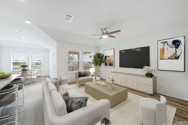 living room with plenty of natural light, light hardwood / wood-style flooring, and ceiling fan