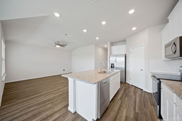 kitchen with a center island with sink, white cabinetry, appliances with stainless steel finishes, light stone countertops, and dark hardwood / wood-style flooring