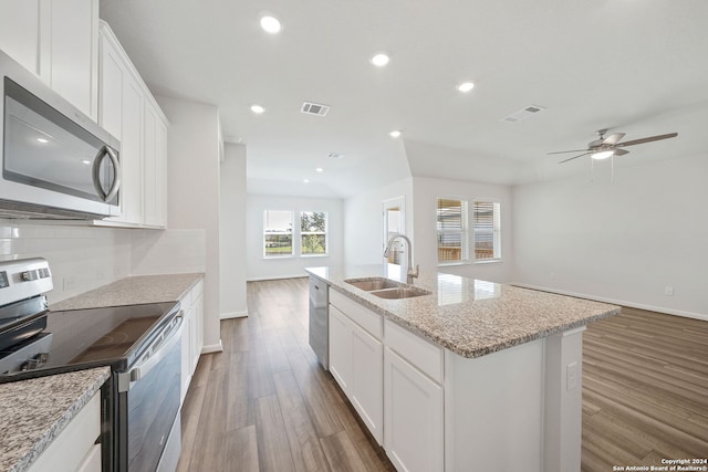 kitchen with light hardwood / wood-style floors, sink, an island with sink, appliances with stainless steel finishes, and white cabinetry