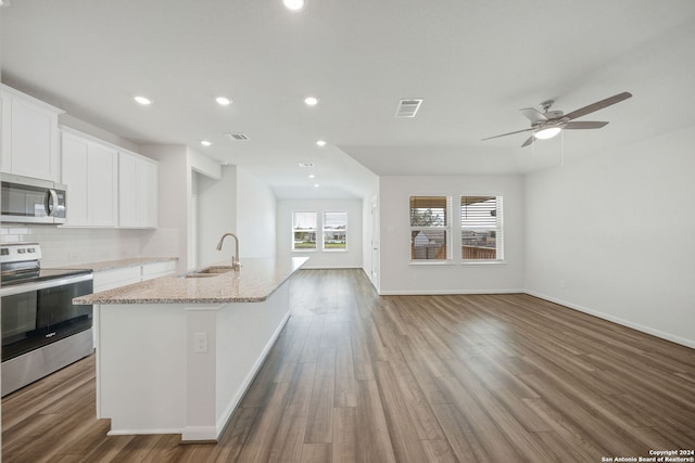 kitchen featuring sink, light stone countertops, dark hardwood / wood-style floors, white cabinets, and appliances with stainless steel finishes