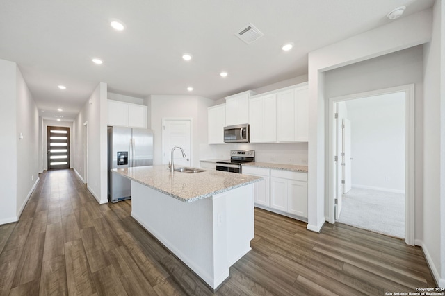 kitchen with a center island with sink, sink, dark hardwood / wood-style floors, appliances with stainless steel finishes, and white cabinetry