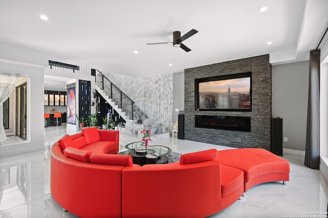 living room featuring a fireplace and ceiling fan