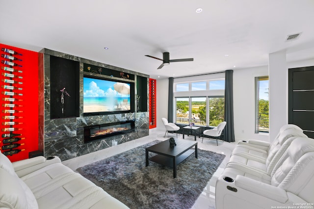 living room with ceiling fan and a fireplace