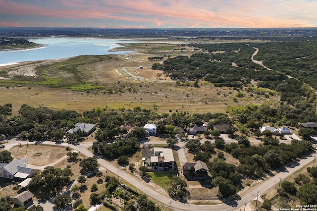 aerial view at dusk featuring a water view