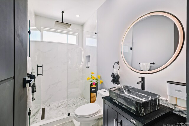 bathroom featuring vanity, toilet, and an enclosed shower