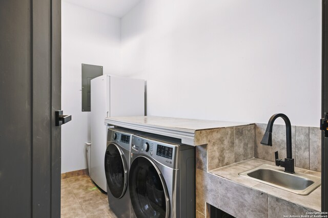 laundry room with separate washer and dryer, light tile patterned flooring, sink, and electric panel