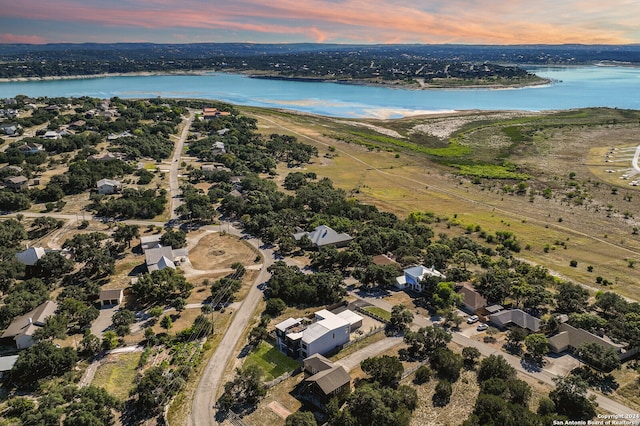 aerial view at dusk featuring a water view