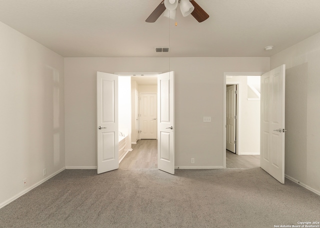 unfurnished bedroom featuring light carpet and ceiling fan