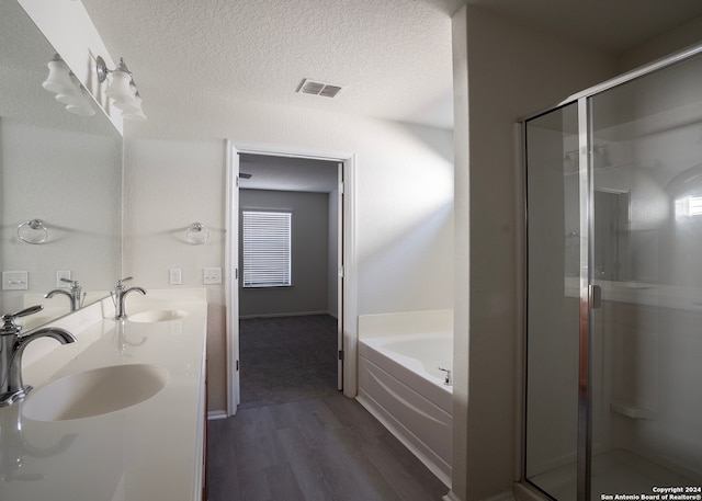 bathroom with independent shower and bath, vanity, a textured ceiling, and hardwood / wood-style flooring