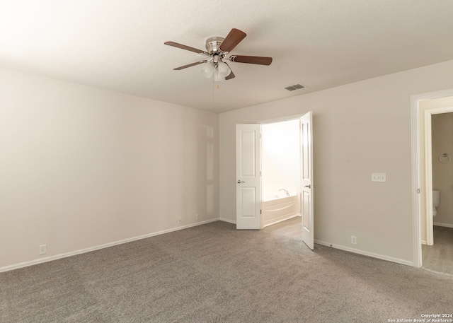 unfurnished bedroom with ensuite bath, ceiling fan, and carpet flooring