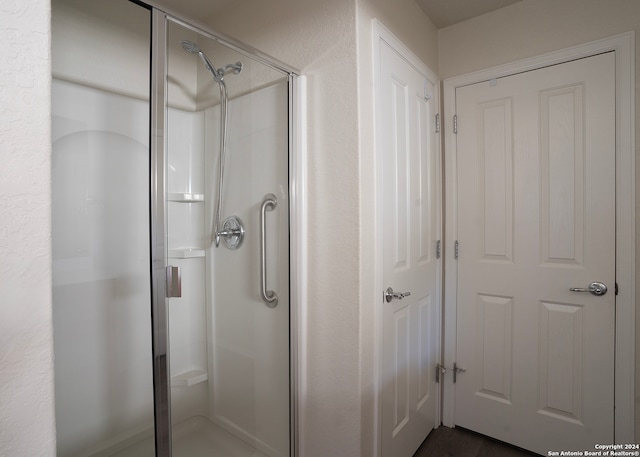 bathroom featuring a shower with shower door