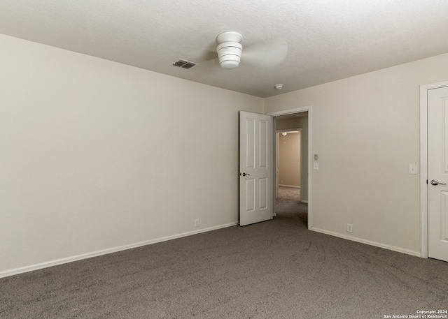 spare room featuring a textured ceiling, ceiling fan, and carpet flooring