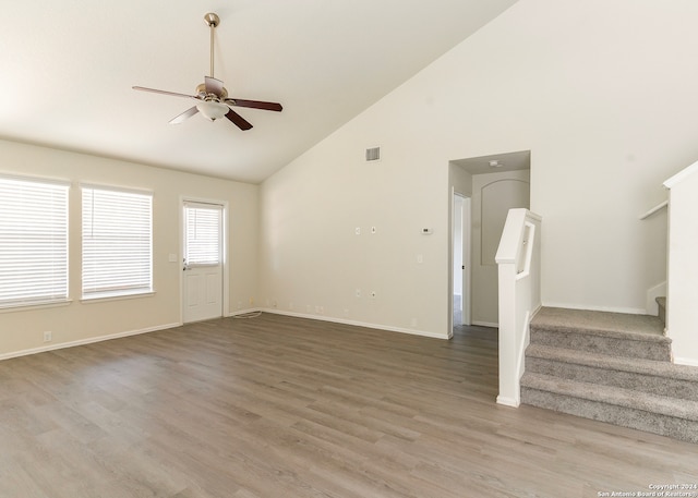 unfurnished living room with high vaulted ceiling, light wood-type flooring, and ceiling fan