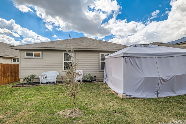 rear view of property featuring a lawn