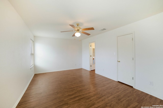 empty room with ceiling fan and dark hardwood / wood-style floors