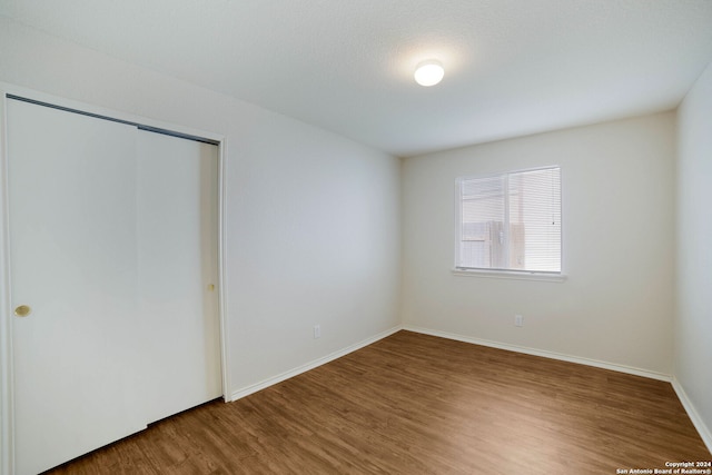 unfurnished bedroom featuring wood-type flooring and a closet