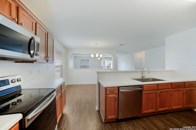 kitchen with a chandelier, dark hardwood / wood-style flooring, decorative light fixtures, sink, and stainless steel appliances