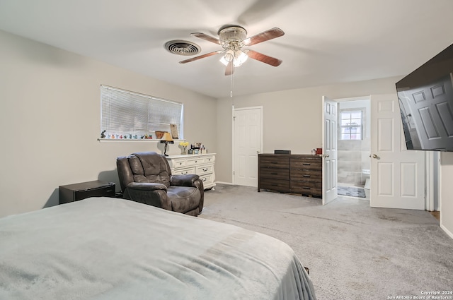 bedroom featuring ceiling fan, light colored carpet, and ensuite bathroom