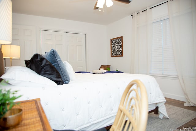 bedroom featuring hardwood / wood-style flooring, ceiling fan, and a closet