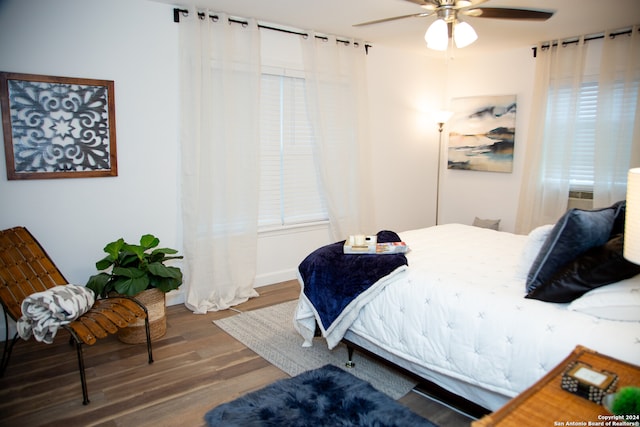 bedroom with wood-type flooring, multiple windows, and ceiling fan