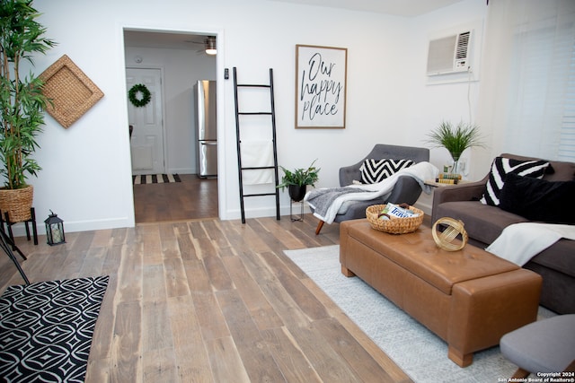 living room featuring a wall unit AC, ceiling fan, and hardwood / wood-style floors