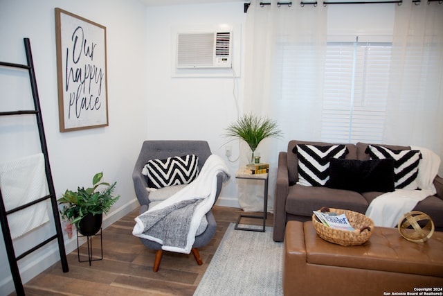 living area with an AC wall unit and wood-type flooring