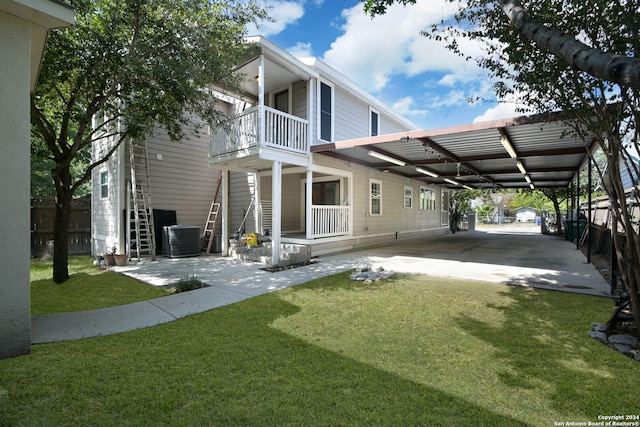 view of home's exterior featuring cooling unit, a carport, a balcony, and a lawn