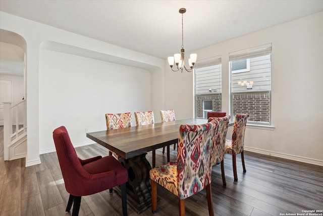 dining area with dark wood-type flooring and a chandelier