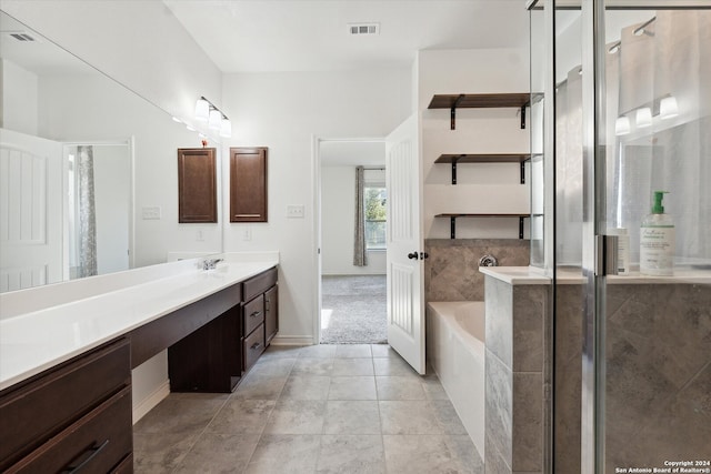 bathroom with vanity, a bath, and tile patterned floors