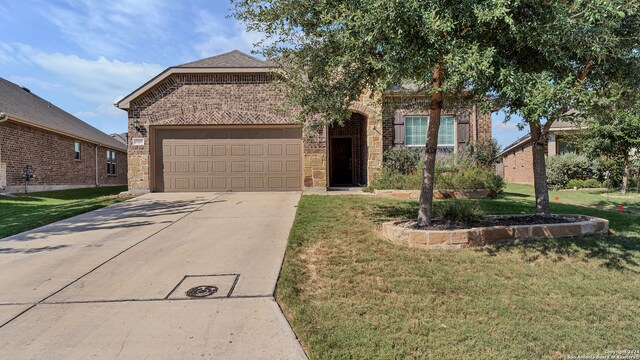 view of front facade featuring stone siding, a garage, driveway, and a front yard