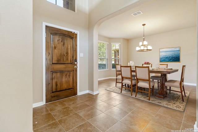 tiled entrance foyer featuring an inviting chandelier