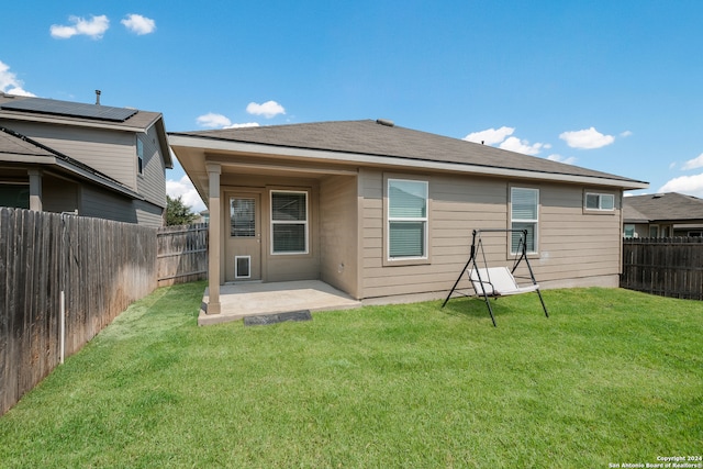 rear view of property with a yard and a patio area