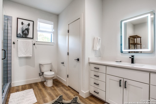 bathroom with vanity, hardwood / wood-style floors, a shower with shower door, and toilet