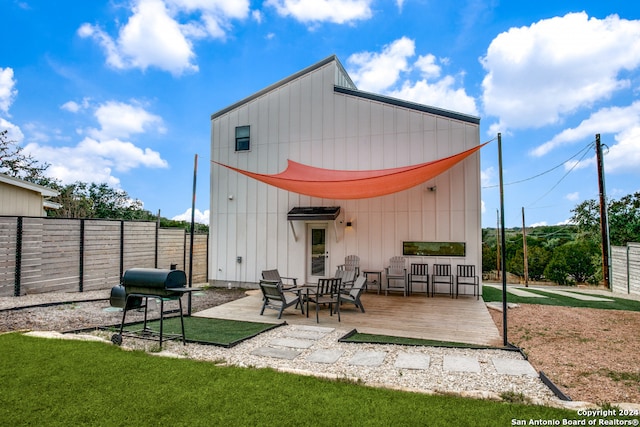 rear view of house with a deck and a yard