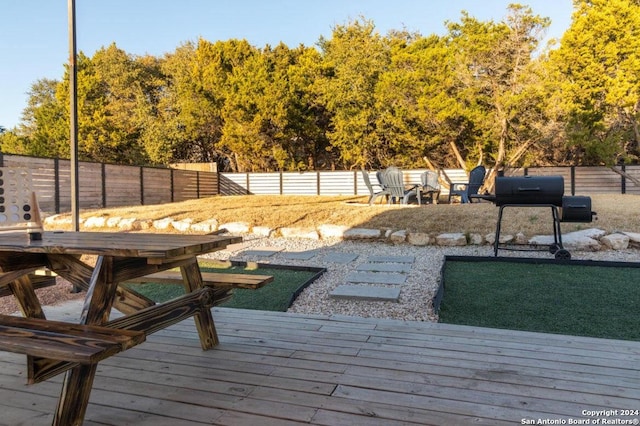 wooden terrace featuring grilling area and fence