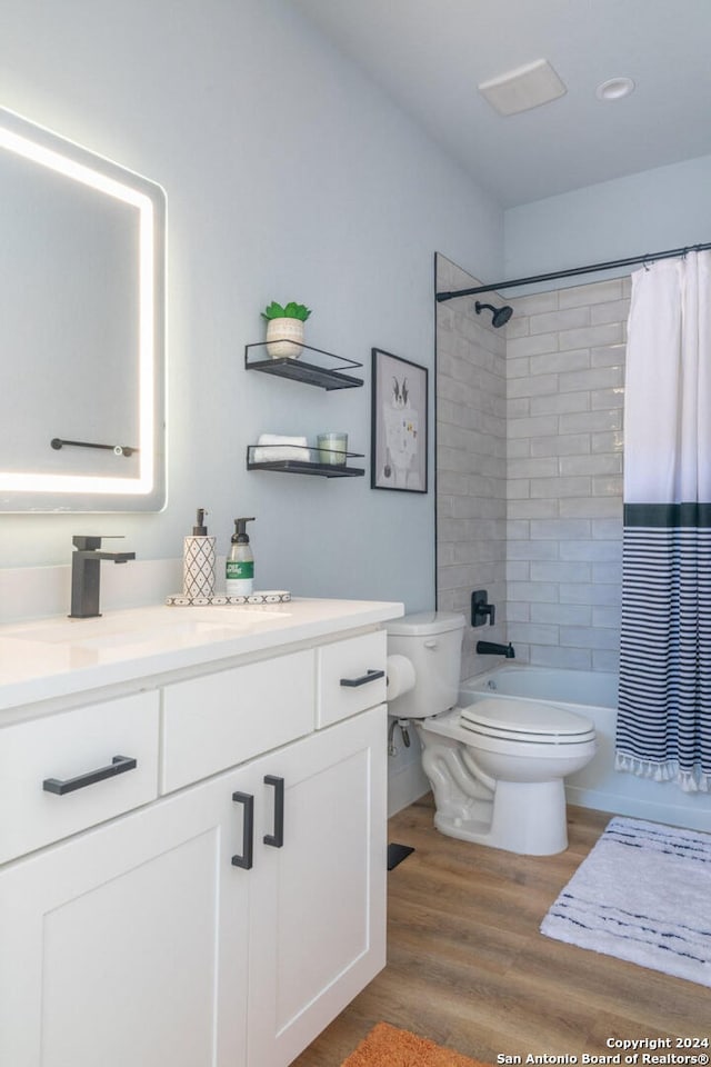 full bathroom featuring vanity, shower / bath combination with curtain, hardwood / wood-style flooring, and toilet