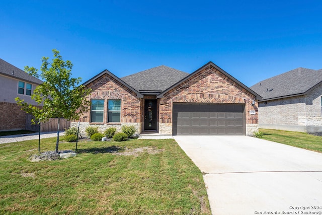 view of front of property featuring a front yard and a garage