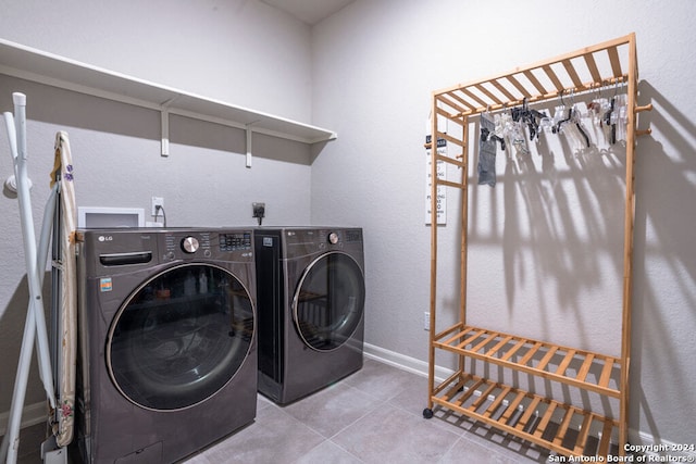 laundry room with washing machine and dryer and light tile patterned floors