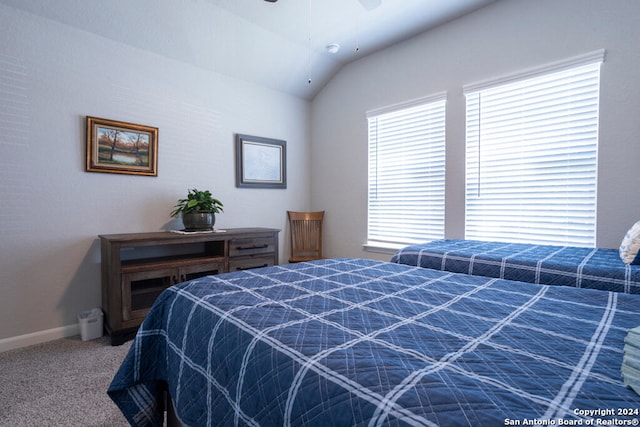 carpeted bedroom with ceiling fan and vaulted ceiling