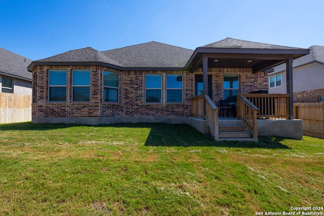 rear view of property featuring a lawn