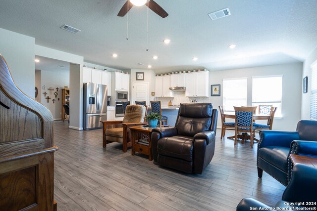 living room featuring light hardwood / wood-style floors and ceiling fan