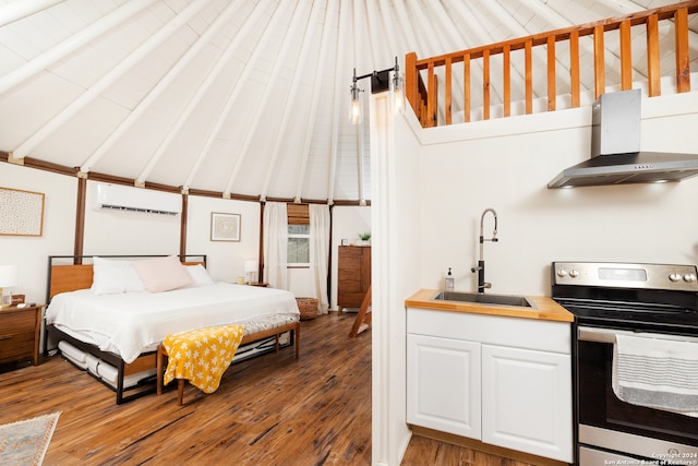 bedroom featuring vaulted ceiling with beams, a wall mounted AC, hardwood / wood-style floors, and sink