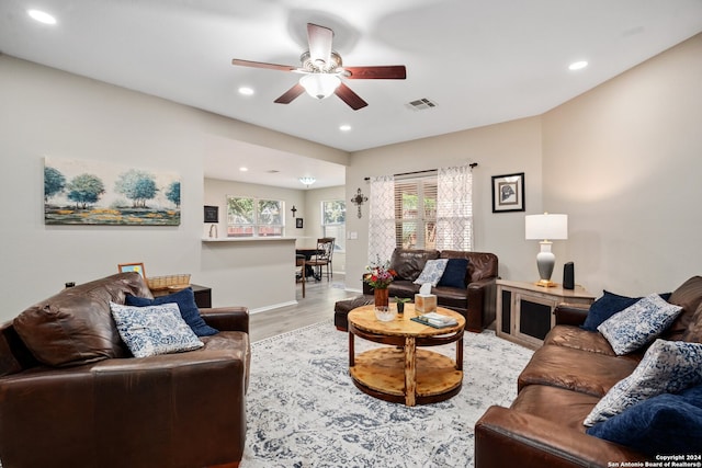 living room with light hardwood / wood-style floors and ceiling fan