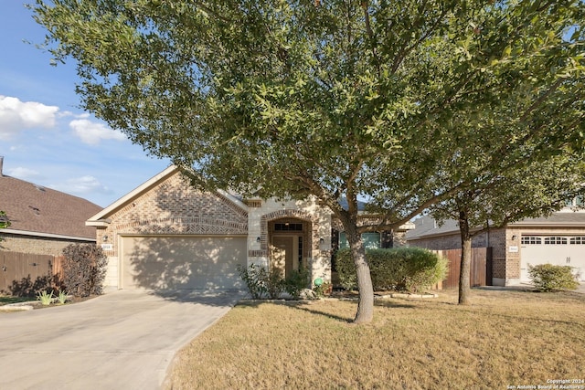 5018 Italica Rd, San Antonio, TX 78253 - view of property hidden behind natural elements featuring brick siding, a garage, driveway, and a front yard