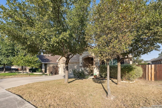 5018 Italica Rd, San Antonio, TX 78253 - view of property hidden behind natural elements featuring a front lawn, fence, driveway, and stone siding