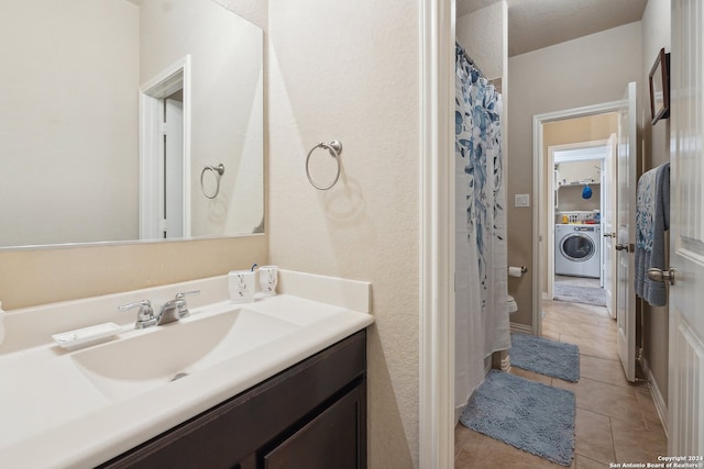 bathroom featuring vanity, tile patterned floors, and washer / dryer