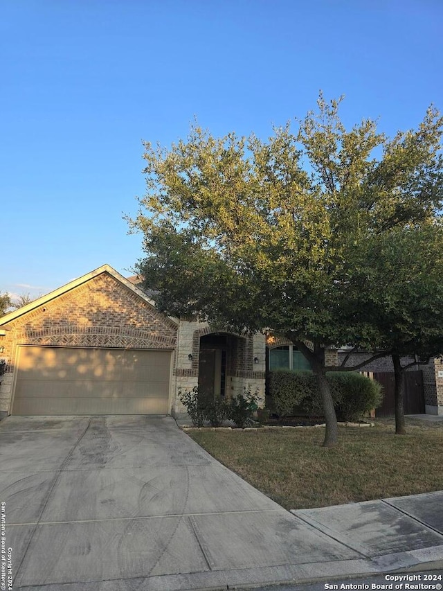 view of front of property featuring a garage and a front lawn